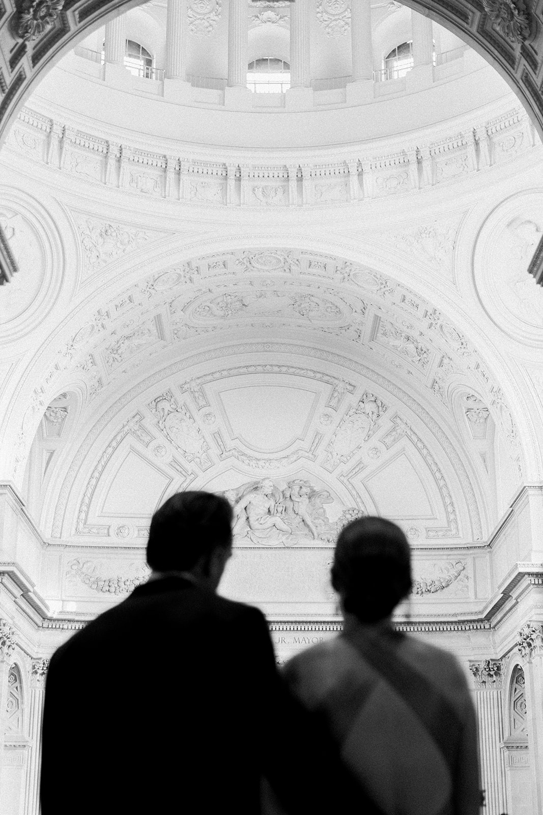 blurry couple looking up at san francisco city hall