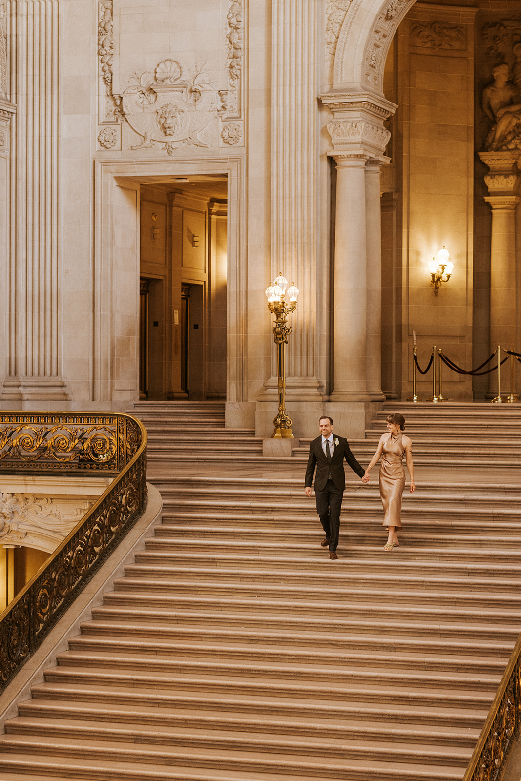 bride and groom on stairs at san francisco city hall