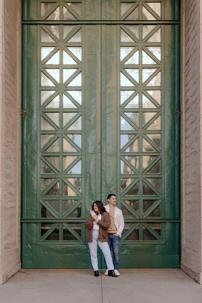 couple posing in front of green door at palace of fine arts in san francisco